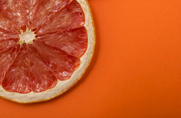 dried rings of grapefruit on orange background
