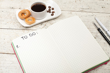 notebook with an inscription, coffee with bagels, pens and pencils