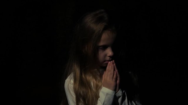 A little girl says a prayer before bedtime