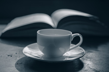 cup of coffee on the background of an open book.