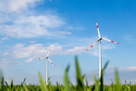 gro&szlig;e Windr&auml;der stehen auf einem Feld und produzieren &Ouml;kostrom