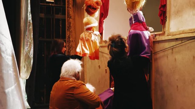 Puppeteer manages puppets behind the scenes at the stage of puppet theater 
