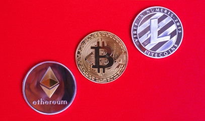 Gold bitcoins digital virtual money on a red background. Metal gold money bitmoy Credit coins - bitkoyn BTK , lithecoin LTC , etherum ETH digital cryptococci