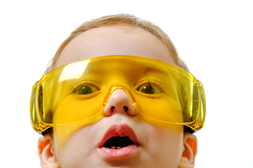 Concept, small smiling boy with protective glasses, looks afar isolated on white background with copy space