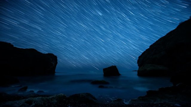 Time lapse. Star trails above the rocky seashore