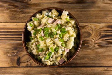 Traditional Russian festive salad Olivier on wooden table