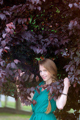 Fototapeta premium portrait of redhead cute girl in purple leaves