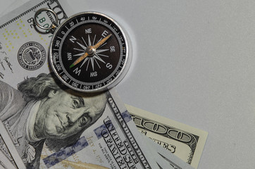 compass on pile of dollar bills