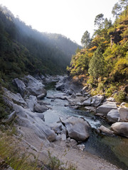 Wanderung durch eine Schlucht mit einem Fluss und gro&szlig;en Felsen in Uttarakhand Indien