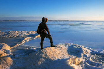 Man on the frozen river during sunset.