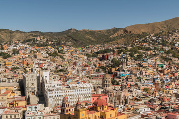 Looking down on a UNESCO Heritage Site-Guanajuato City, Mexico, from up on a hill, with a view of the Basilica, Guanajuato University, many other buildings and colorful houses