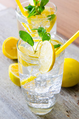 Glasss of mojito with lemon and drinking straw
