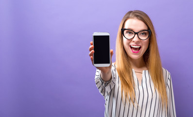 Young woman holding out a cellphone in her hand