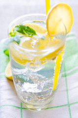 Glasss of mojito with lemon and drinking straw