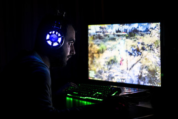 Young gamer playing video game wearing headphone. © sezer66