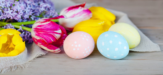 Fototapeta na wymiar Easter eggs and spring flowers, Easter decoration on a wooden background, holiday concept.