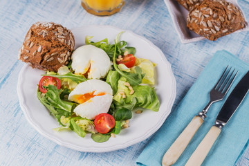 Poached egg with green salad, tomatoes, wholemeal bread and orange juice