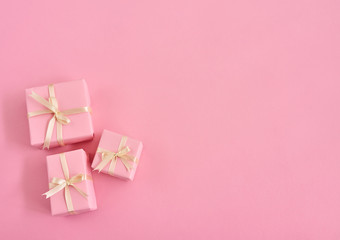 Valentines day background with tiny pink gift boxes over pink background. Space for text