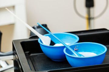 Two plastic bowls with bleach hair dye