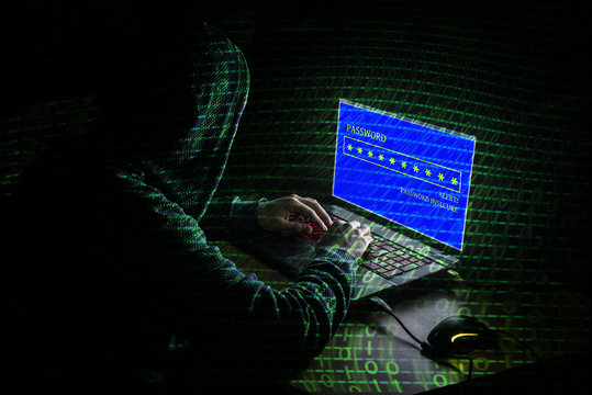 Young hacker in data security concept on a dark background