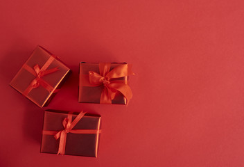 Tiny red gift boxes over red background. Valentones day background