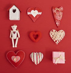 A lot of differen hearts., gift boxes and valentines toy over red background. Design mockup