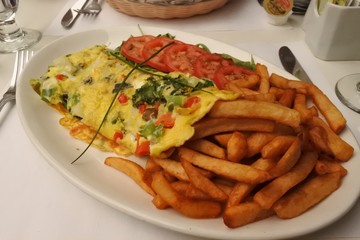 レストランのオムレツ。フライドポテトとトマトとともに。