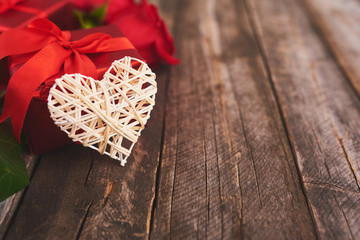 Valentines day background with gift box and white heart over wood board