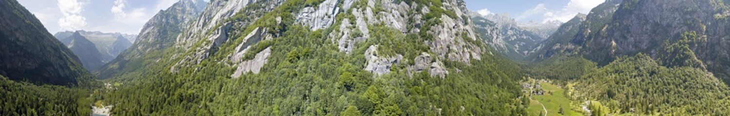 Fototapeta na wymiar Vista aerea della Val di Mello, una valle verde circondata da montagne di granito e boschi, ribattezzata la Yosemite Valley italiana dagli amanti della natura. Val Masino, Valtellina, Sondrio. Italia