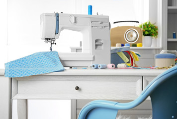 Sewing machine with fabric on table in tailor workshop
