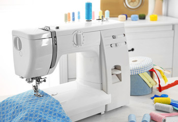 Sewing machine with fabric on table in tailor workshop