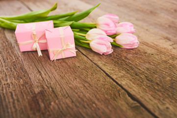 Valentines day background with pink tulips and gift box over wood board