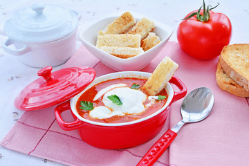 Tomato soup with sour cream, croutons and fresh parsley leaves.
