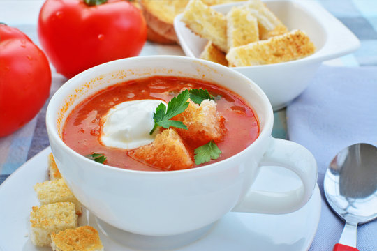 Tomato soup with sour cream, croutons and fresh parsley leaves.