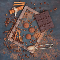 Composition with chocolate, coffee beans, truffles on wooden background