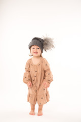 Portrait of happy little girl. Cute little girl in beige dress in a gray hat isolated on white background.