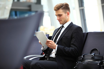 Businessman Using Digital Tablet In Airport Departure Lounge