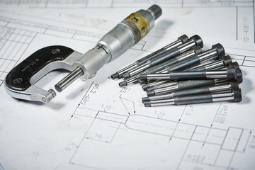 metalworking industry and machining. Details with measuring micrometer on print drawing