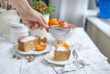 sweet homemade pastries with persimmons, on white tableware and white background, sprinkled with powdered sugar. Free method for text.
