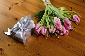 bouquet of tulips pink on a beautiful wooden background and gifts for March 8, beloved woman