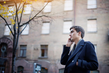 Portrait of a young guy with a phone in his hands.