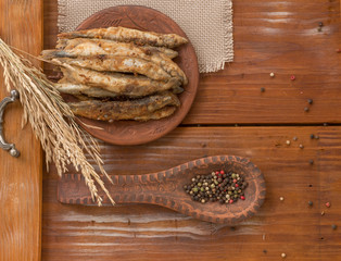 Fried small fish on the wooden background