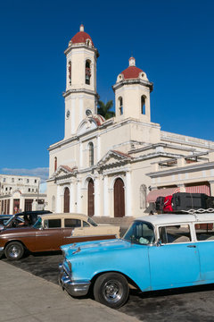 Old cars parked in the Jose Marti Park, in front of the Purisima Concepcion Cathedral. Cienfuegos, Cuba.