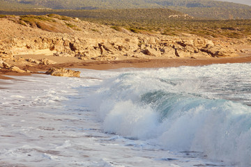 Beautiful wild beach with clear turquoise water and waves.