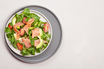 Fresh salad made of salmon, tomatoes and avocado