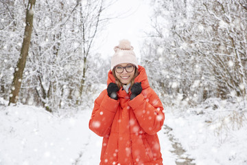  Woman in snowfall. Close-up portrait shot of a happy middle aged female wearing hat while standing outdoor and enjoy snowfall. 