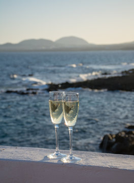 Two glasses with champain or cava served outside on terrace, luxury resort with sea view, romantic vacation