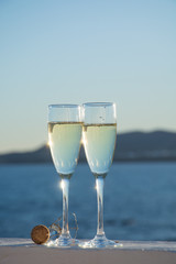 Two glasses with champain or cava served outside on terrace, luxury resort with sea view, romantic vacation