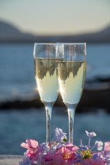 Two glasses with champain or cava served outside on terrace, luxury resort with sea view, romantic vacation