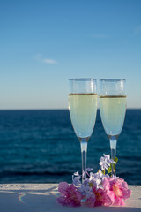 Two glasses with champain or cava served outside on terrace, luxury resort with sea view, romantic vacation